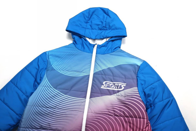 A blue winter coat with a hood, featuring a wave design in purple and pink and a logo on the front.