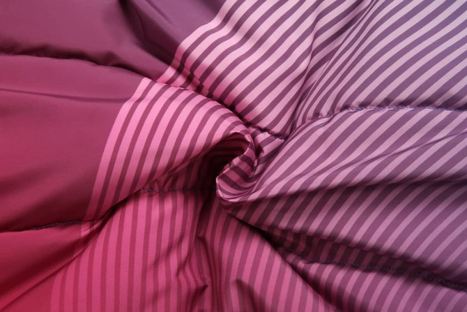 A textured fabric featuring gradients of pink and purple stripes, showcasing the material of a winter coat.