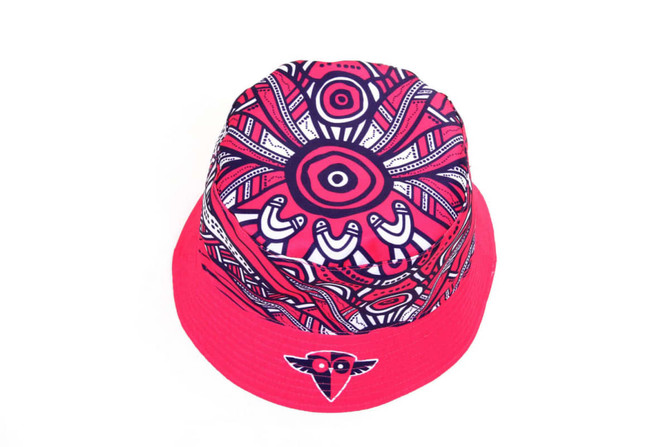 A reversible bucket hat featuring a vibrant pink design with intricate patterns and a logo on the front.