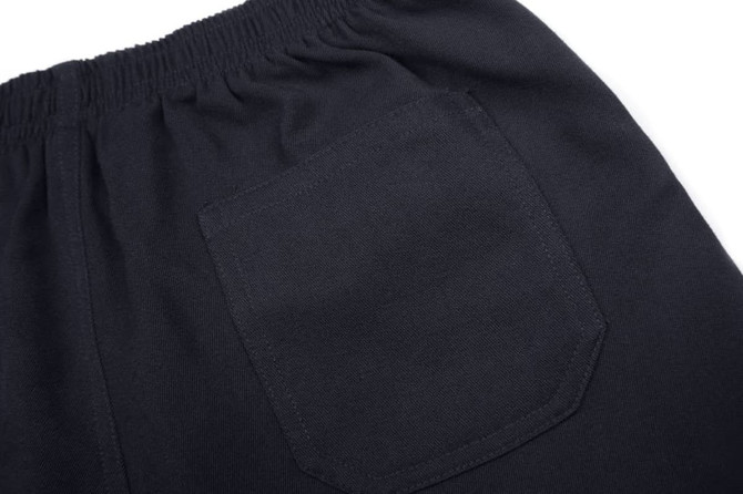 A close-up of black shorts featuring an elastic waistband and a back pocket. The fabric appears smooth and sturdy.