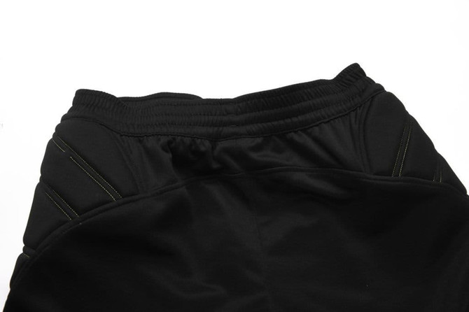Black soccer goalkeeper pants featuring a drawstring waist and green stitching details. Includes a logo on the waistband.