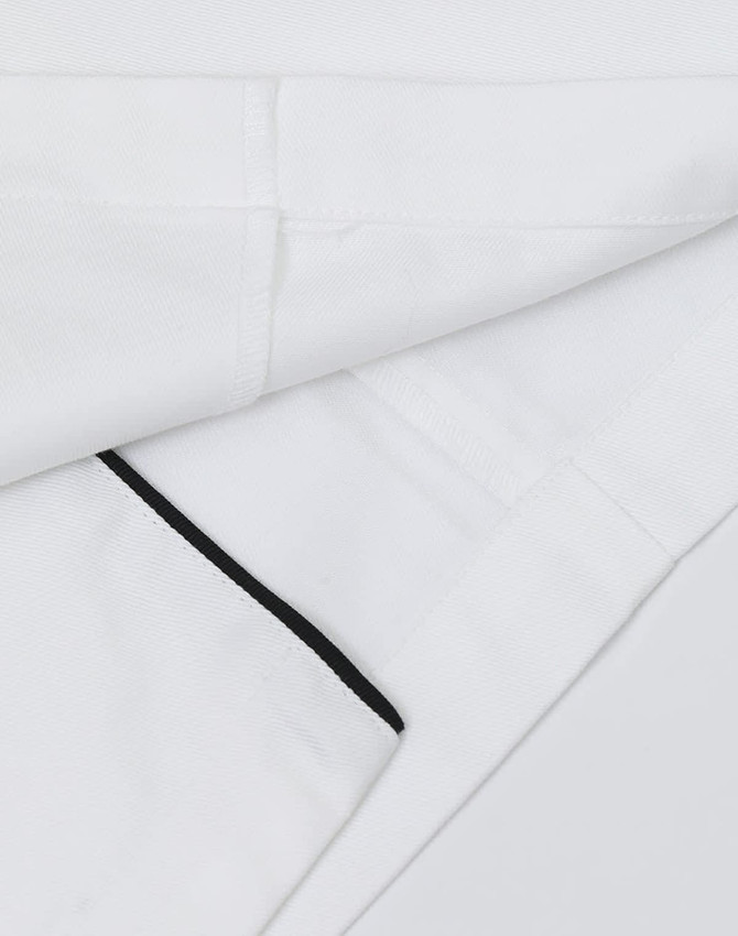 A unisex executive chef jacket in white with black detailing and a logo on the fabric.
