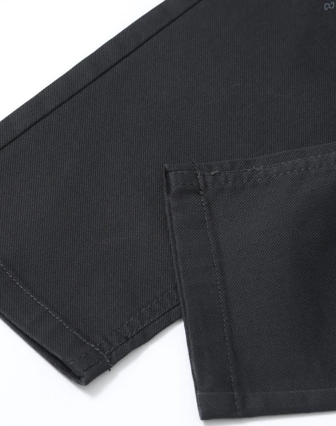 A close-up of men's black flexi chino pants, highlighting the fabric and stitching details.