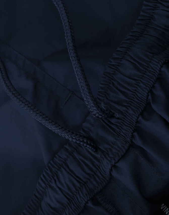 Navy unisex mercerised cotton shorts featuring an elastic waistband with a drawstring. Includes a logo detail.
