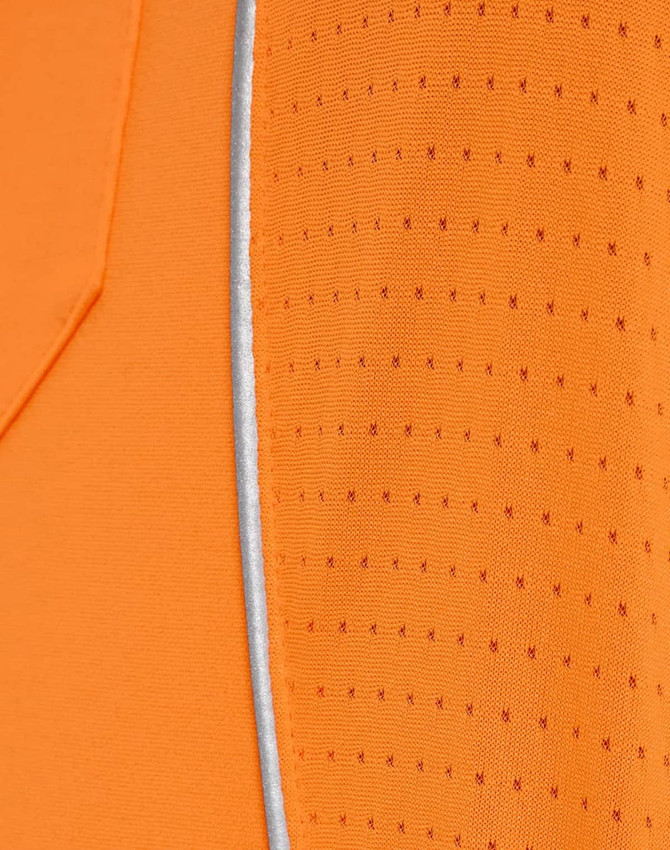 Close-up of an orange polo shirt featuring a textured pattern and a reflective trim. The shirt has a logo.