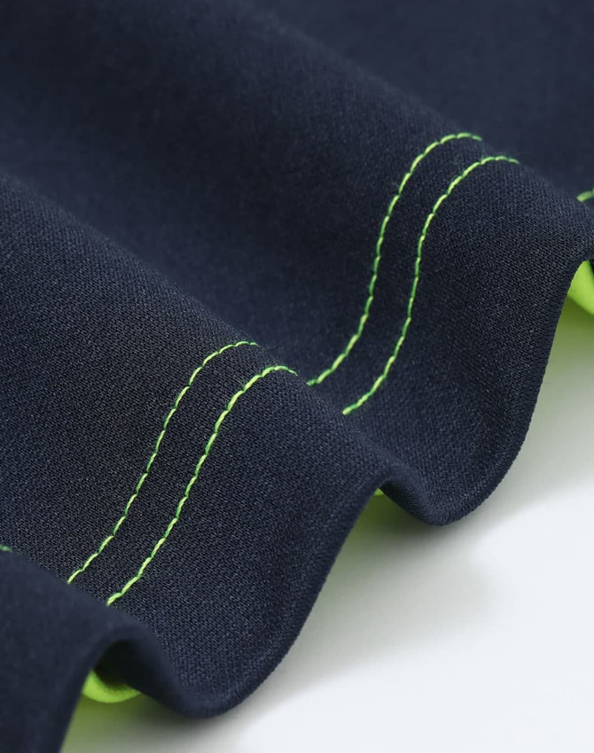 A close-up of a navy polo shirt with bright green stitching and detailing along the edges. It features a logo.