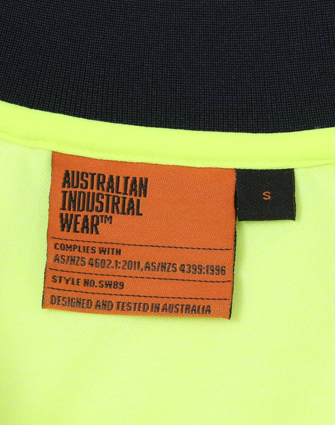 A bright yellow safety polo shirt with a dark collar, featuring a logo and a care label inside.