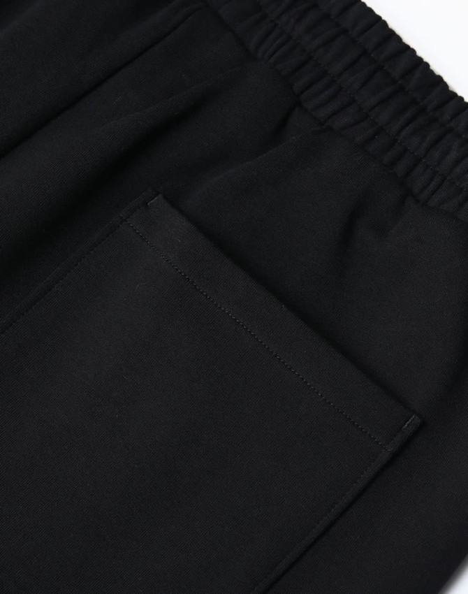 Black unisex sweatpants with an elastic waistband and a patch pocket on the side. Features a logo.