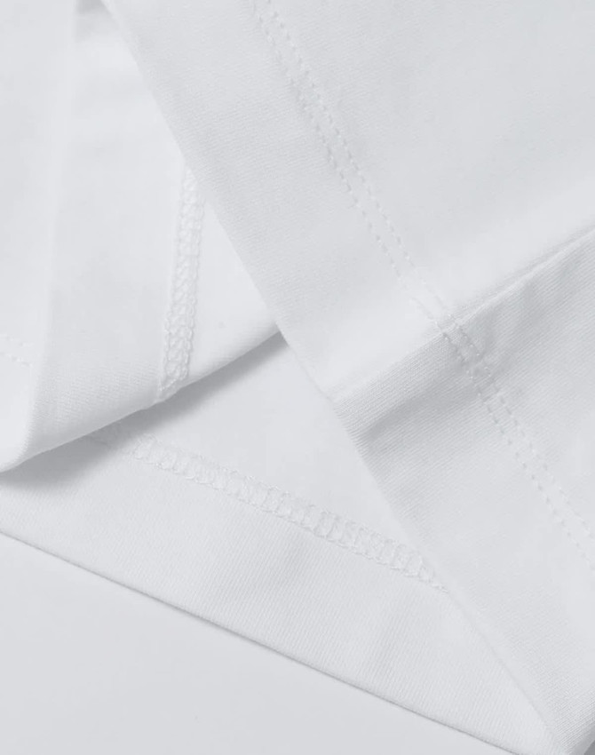 A white cotton tee with detailed stitching, featuring a relaxed fit and short sleeves. It has a logo.