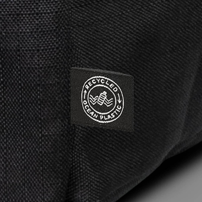 A black backpack made from recycled ocean plastic with a small logo patch.