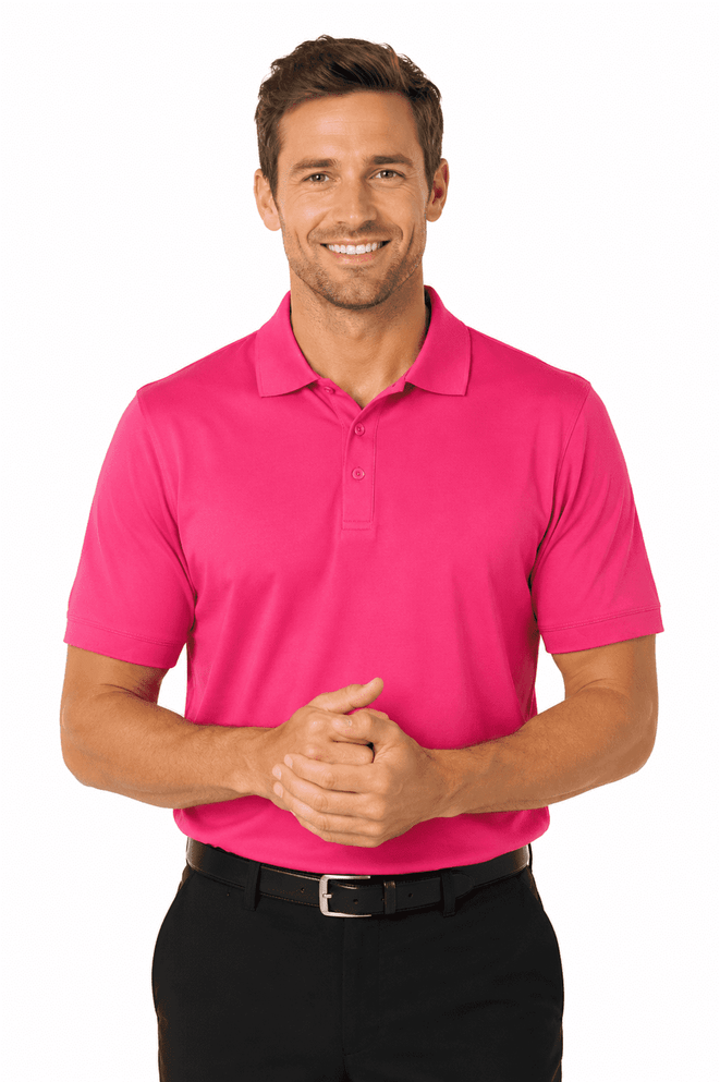 A man wearing a vibrant pink polo shirt, smiling with hands clasped, paired with black trousers. The shirt features a logo.