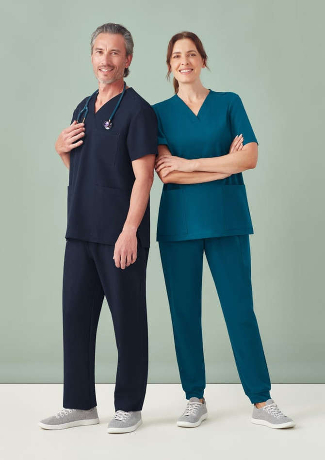 Unisex scrub pants in navy and teal, worn by a man and woman. The attire features a logo and a relaxed fit.