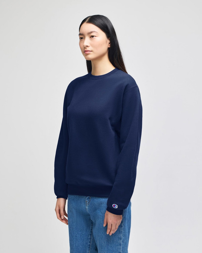 A navy blue crewneck sweatshirt displayed on a model, featuring a small logo on one sleeve.