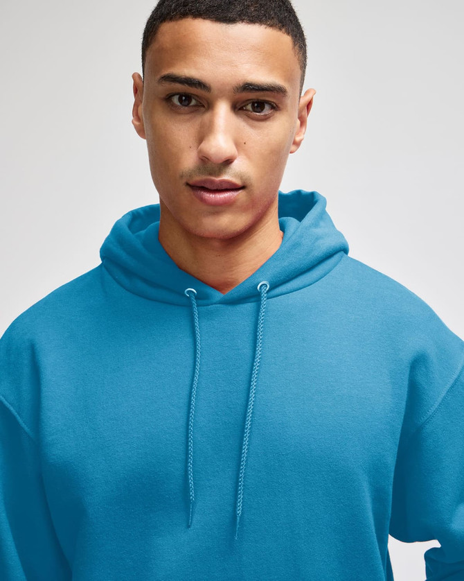 A blue pullover hooded sweatshirt worn by a model, featuring a drawstring hood.