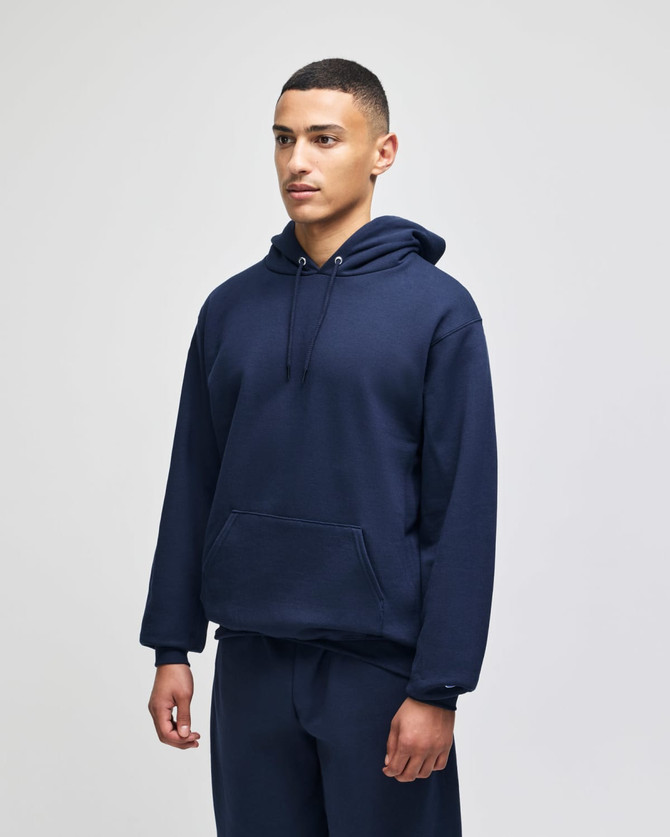 A navy hooded sweatshirt featuring a front pocket and a casual fit, modelled by a young man.