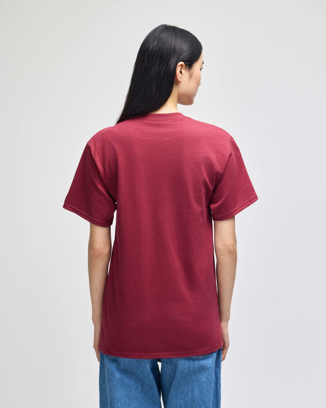 A maroon short-sleeve t-shirt viewed from the back, featuring a logo. The wearer has long black hair.