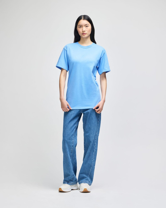 A blue short-sleeve t-shirt displayed on a model, paired with loosely fitted jeans. The shirt features a logo.