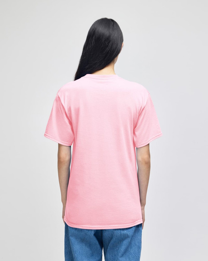 A pink short-sleeve t-shirt viewed from the back, featuring a logo. The wearer has long hair and is dressed in blue jeans.