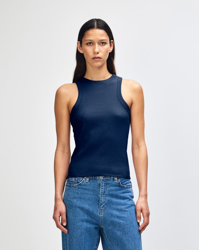 A fitted women's tank top in navy blue, featuring a ribbed design and a logo on the side.