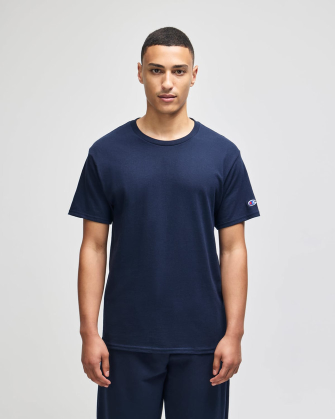 A navy blue Champion Adult Jersey Short Sleeve T-Shirt, displayed on a model standing against a neutral background.