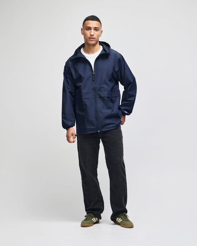 A navy blue full-zip anorak jacket with a hood and pockets, worn by a model standing against a plain background.