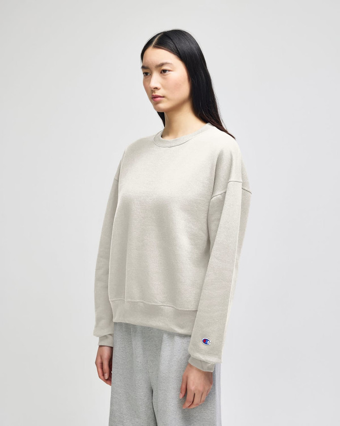 A light grey women's crewneck sweatshirt with a relaxed fit and a small logo on the sleeve.