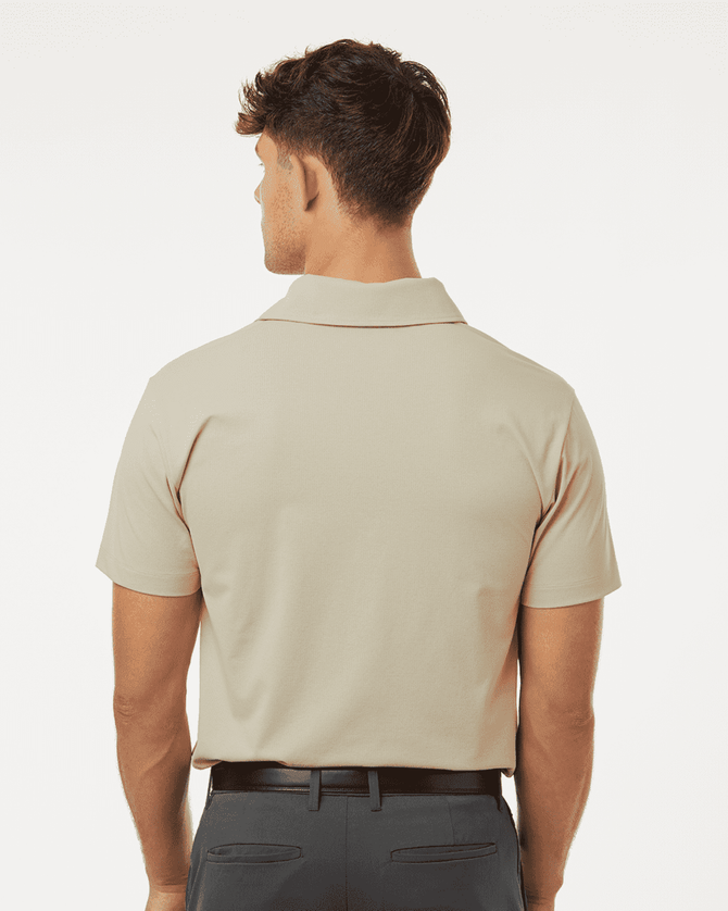 A beige polo shirt with a classic collar and short sleeves, featuring a logo on the back.