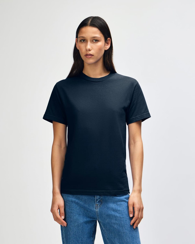 A unisex heavyweight cotton t-shirt in black, displayed on a model with straight black hair, paired with blue jeans.
