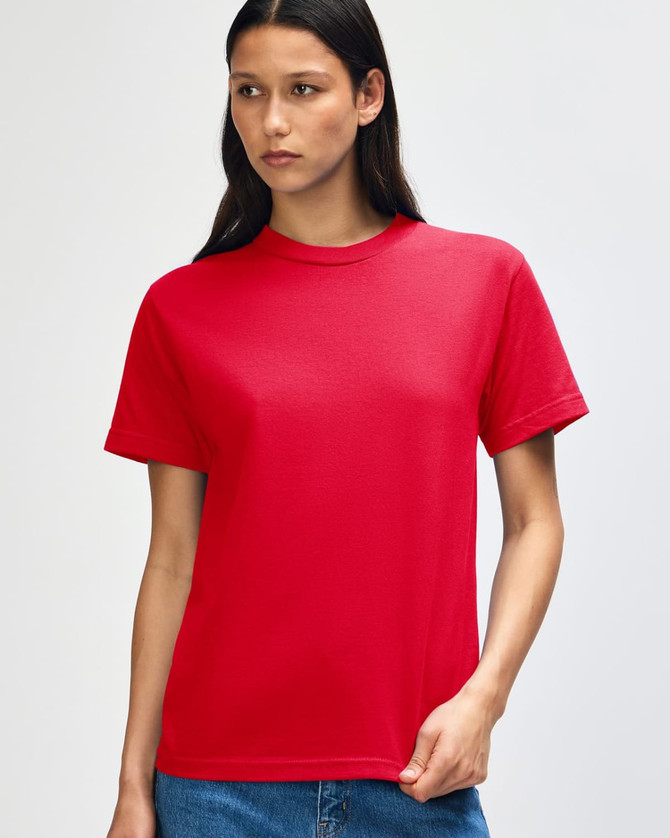 A red heavyweight cotton unisex T-shirt displayed on a model with curly hair. The shirt has a logo on it.