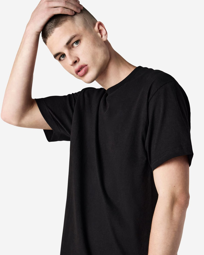 A unisex heavyweight cotton T-shirt in black, featuring a logo, worn by a model with a shaved head.