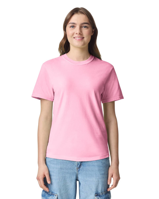 A pink adult heavyweight t-shirt with short sleeves, featuring a logo on the front.