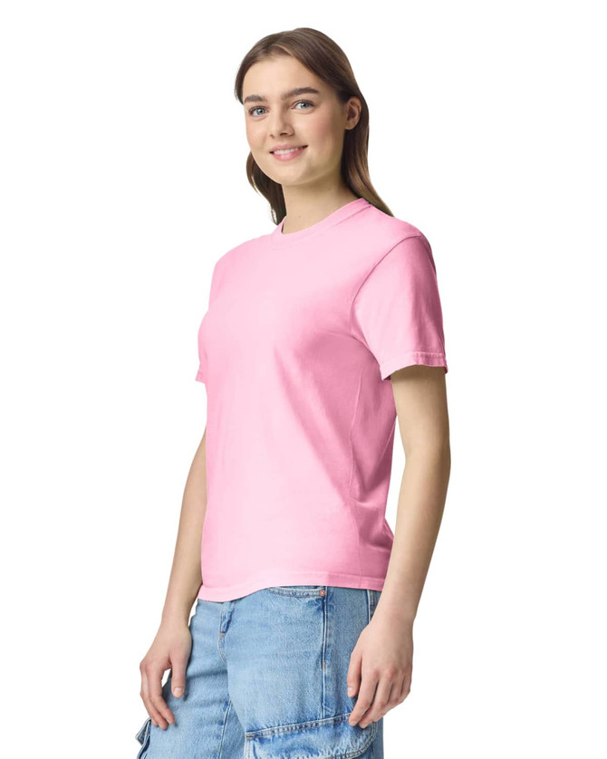 A pink adult heavyweight T-shirt displayed on a model, featuring short sleeves and a relaxed fit.