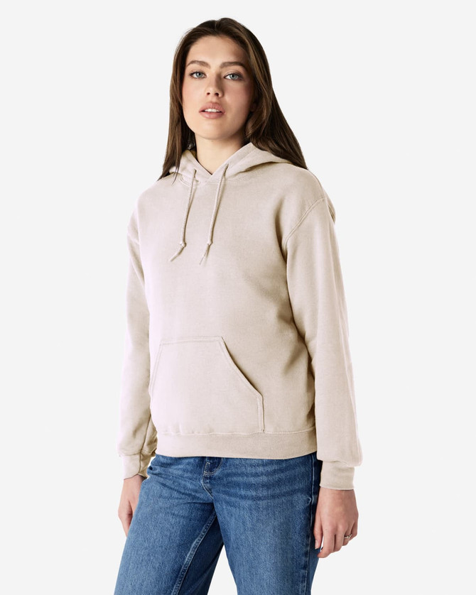 A light beige hooded sweatshirt with a front pocket and drawstrings, worn by a model. The garment has a logo.