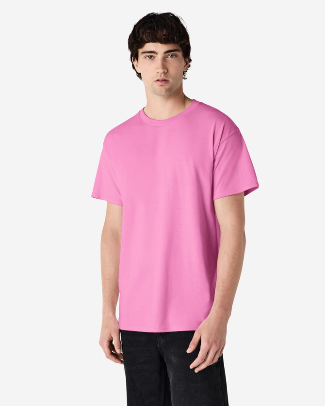 A pink Gildan Ultra Cotton adult t-shirt displayed on a model, featuring short sleeves and a basic cut.