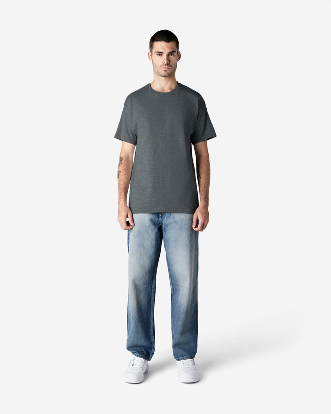 A grey Gildan Ultra Cotton adult T-shirt displayed on a male model, paired with light blue jeans and white shoes.