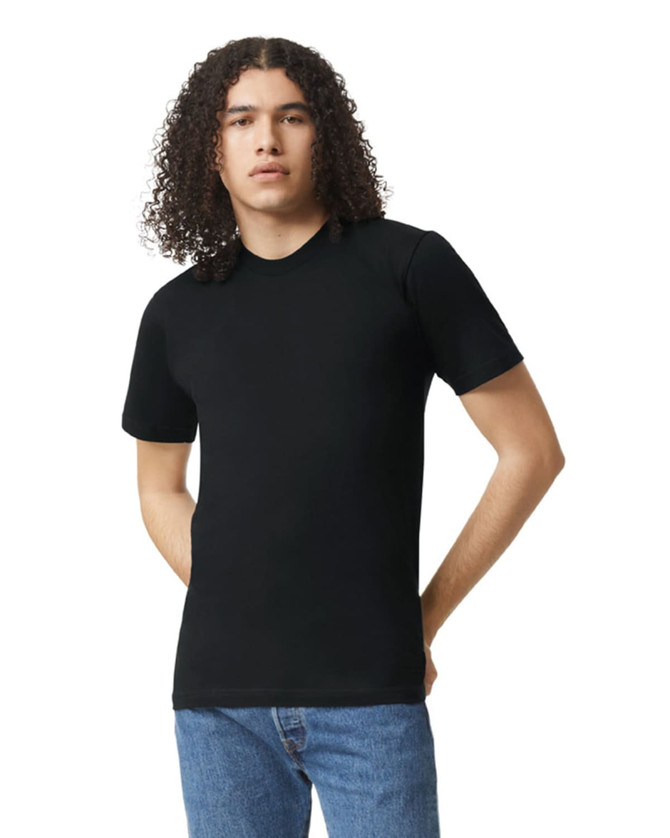 A model wearing a black unisex short sleeve t-shirt, paired with blue jeans. The t-shirt features a logo.