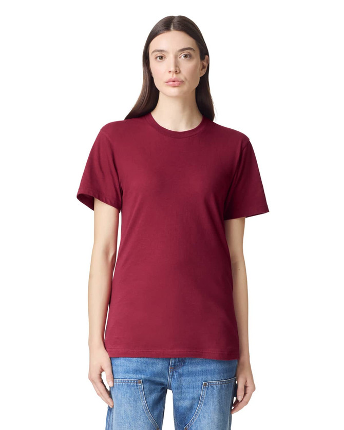 A maroon unisex fine jersey short sleeve t-shirt displayed on a model. The shirt features a logo.