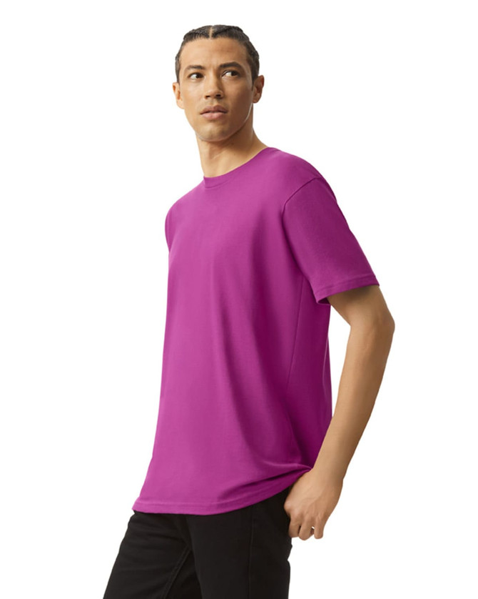 A unisex fine jersey short sleeve t-shirt in vibrant purple, worn by a model posing sideways. The shirt features a logo.