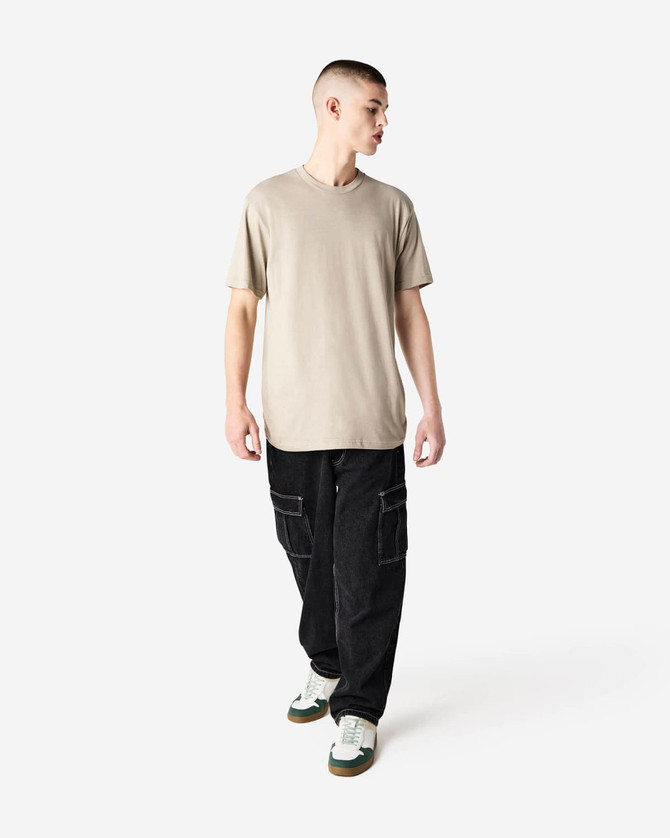 A unisex short sleeve T-shirt in beige, paired with black cargo pants, featuring a logo on the shirt.