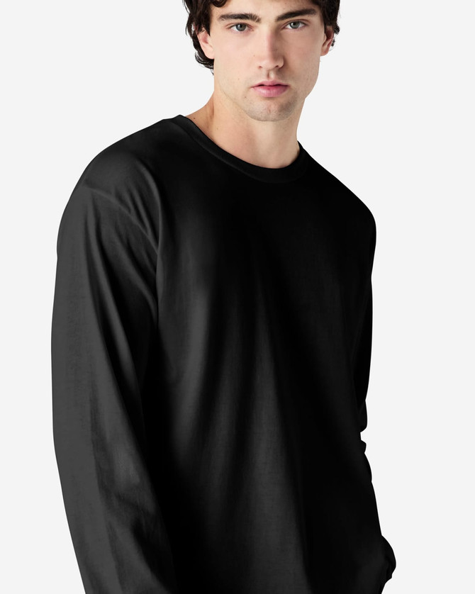 A model wearing a black long sleeve t-shirt made of ultra cotton, featuring a simple design and relaxed fit.