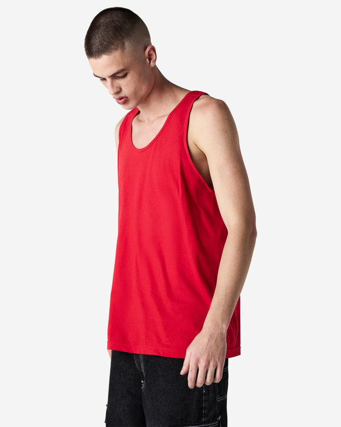 A red unisex fine jersey tank top is displayed on a model against a plain background. It has a logo on it.