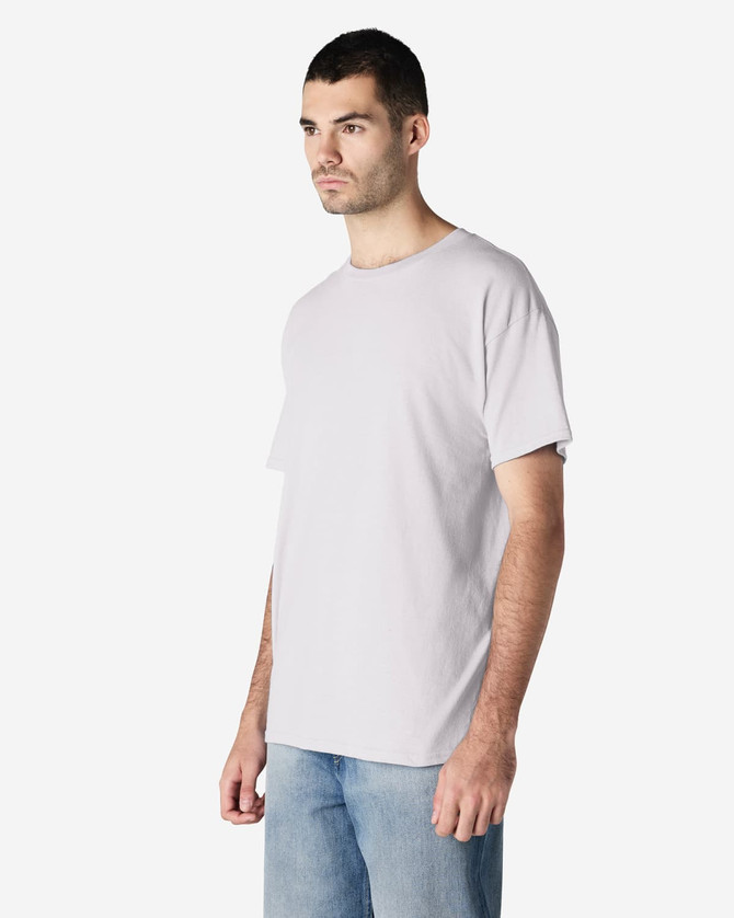 A light grey adult t-shirt displayed on a model, featuring a simple design and a branding logo.
