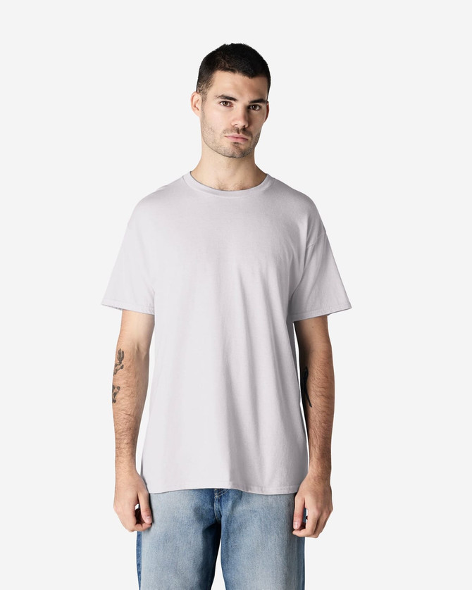 A grey Gildan Heavy Cotton Adult T-Shirt worn by a model, featuring a simple design and relaxed fit.