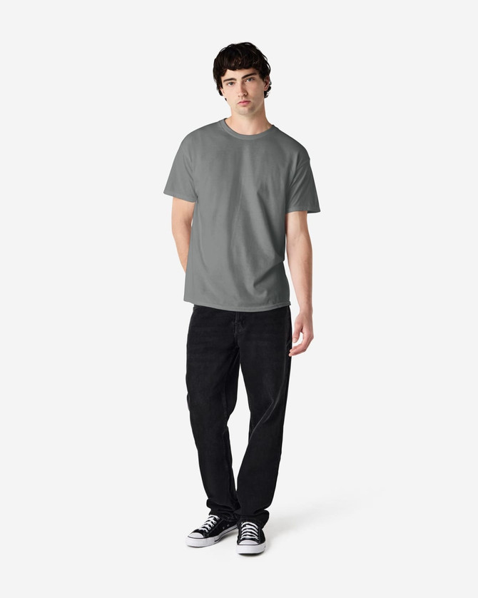 A grey Gildan Heavy Cotton Adult T-Shirt displayed on a male model, paired with black jeans and sneakers.