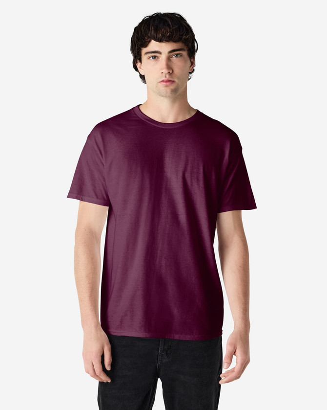 A maroon Gildan Heavy Cotton Adult T-Shirt on a model, featuring short sleeves and a round neck, with a logo.