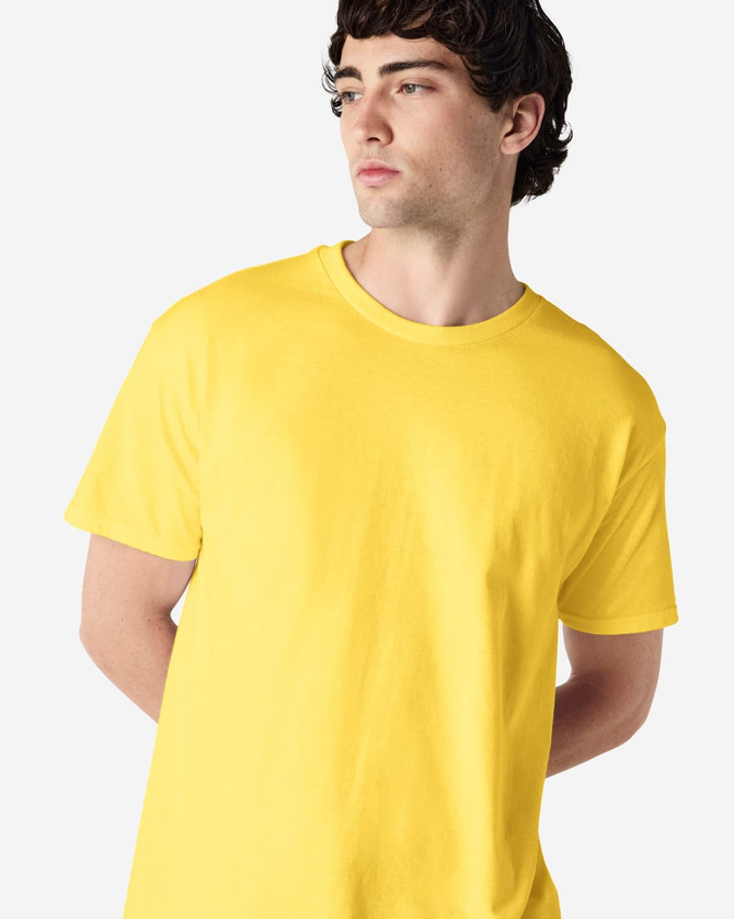 A yellow Gildan Heavy Cotton Adult T-Shirt displayed on a model, featuring a logo.