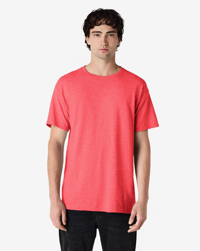 A model wearing a vibrant coral Gildan Heavy Cotton Adult T-Shirt with a relaxed fit.