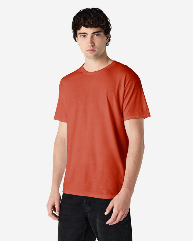 A man wearing a Gildan Heavy Cotton adult T-shirt in a vibrant orange colour, featuring a logo.
