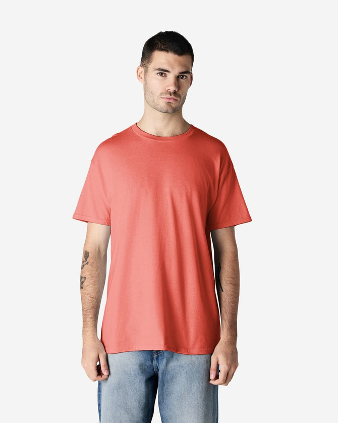 A side view of a man wearing a coral Gildan Heavy Cotton adult t-shirt with short sleeves.