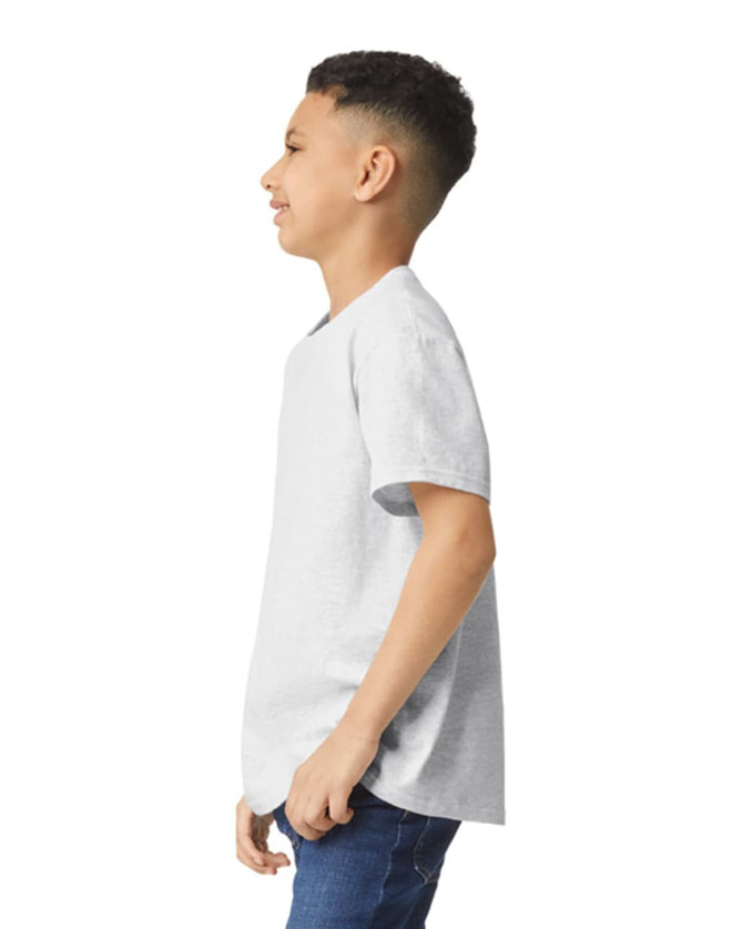 A young boy wearing a light grey Gildan Heavy Cotton Youth T-Shirt, standing sideways with a slight smile.